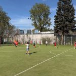 Grupa dzieci grająca na boisku w piłkę nożną