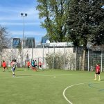 Grupa dzieci grająca na boisku w piłkę nożną
