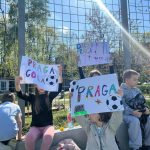 Grupa dzieci z plakatami Praga gola