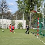Grupa dzieci grająca na boisku w piłkę nożną