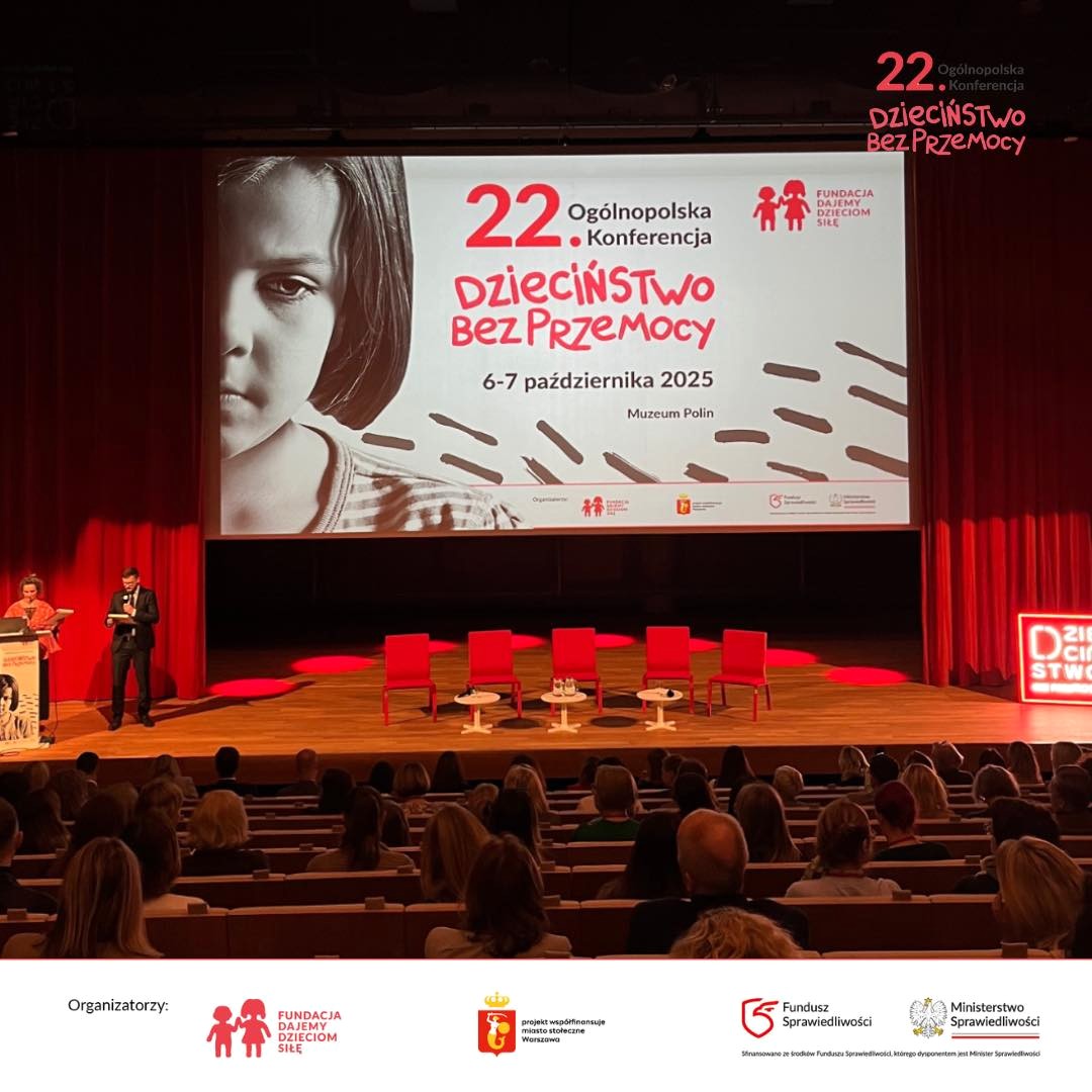 Zdjęcie przedstawiające salę konferencyjną, w tle wyświetlany baner z dzieckiem i napisem 22. ogólnopolska konferencja Dzieciństwo bez przemocy, 6-7 października 2025, Muzeum Polin